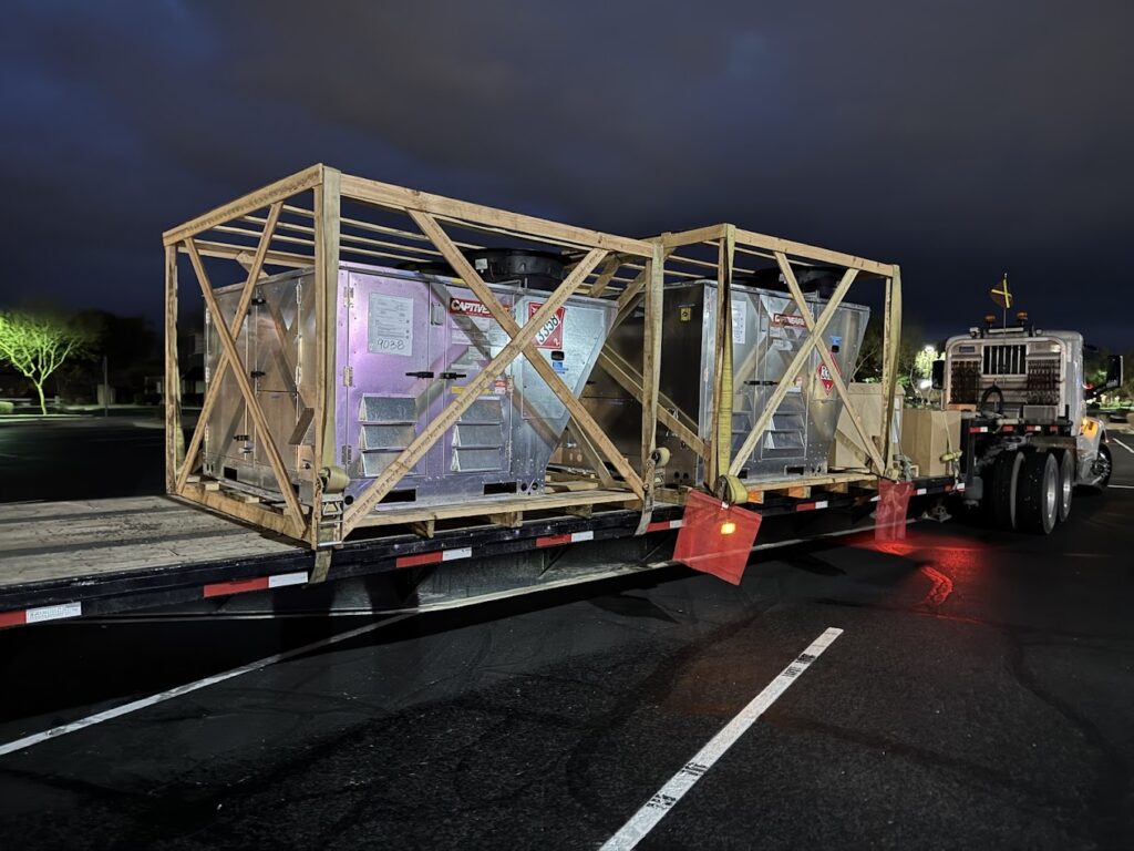 HVAC units on a flatbed truck, ready for Home installation in Phoenix, AZ. Commercial air conditioning equipment delivery for homes.